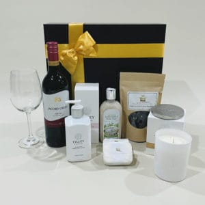 Pamper Hamper With Red Wine image. Goats milk lotions & soaps scented sweet pea candle chocolate coated almonds & classic red wine.