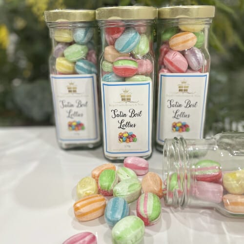 A jar of boiled lollies labeled "taste the rainbow." These multicoloured candies offer nostalgic flavours and a delightful burst of sweetness.