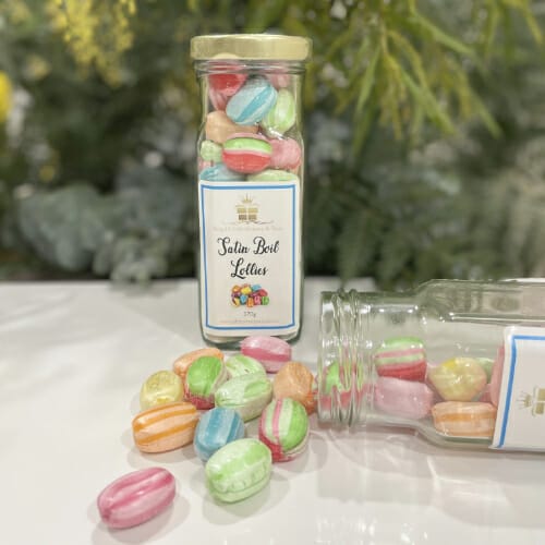 A jar of boiled lollies labeled "taste the rainbow." These multicoloured candies offer nostalgic flavours and a delightful burst of sweetness.